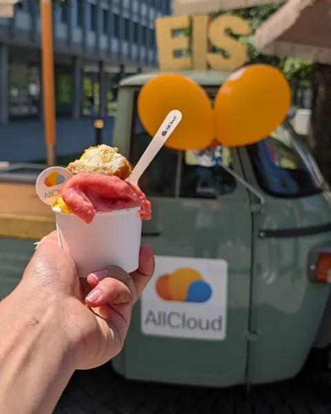 Eisbecher mit essbarem AllCloud-Logo vor der gebrandeten Ape